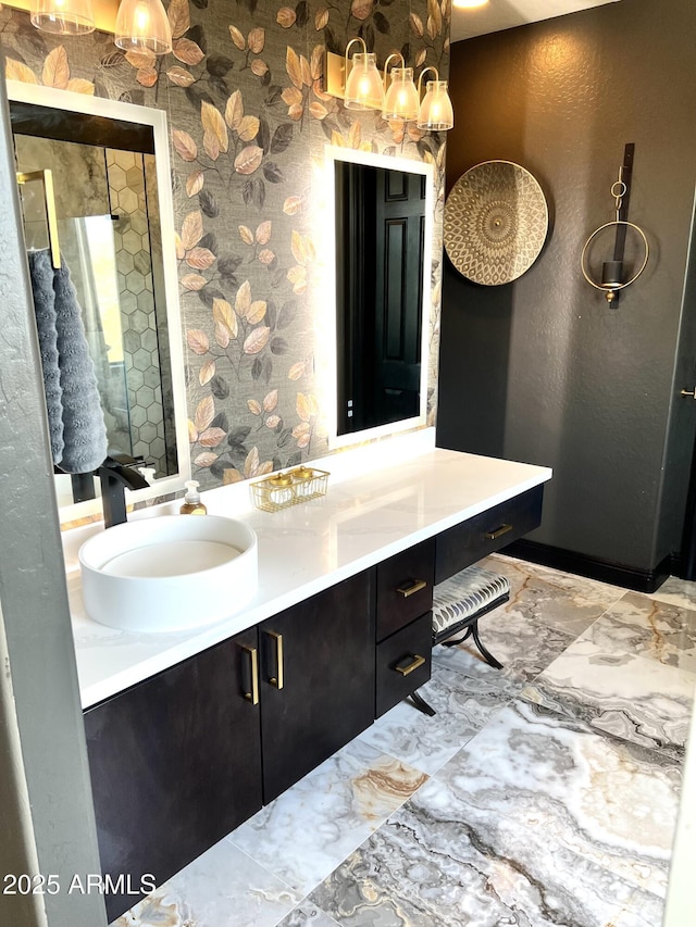 full bath with marble finish floor, a shower, vanity, and wallpapered walls