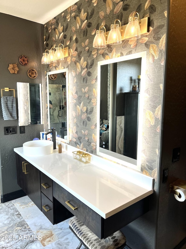 full bathroom with a stall shower, vanity, and wallpapered walls