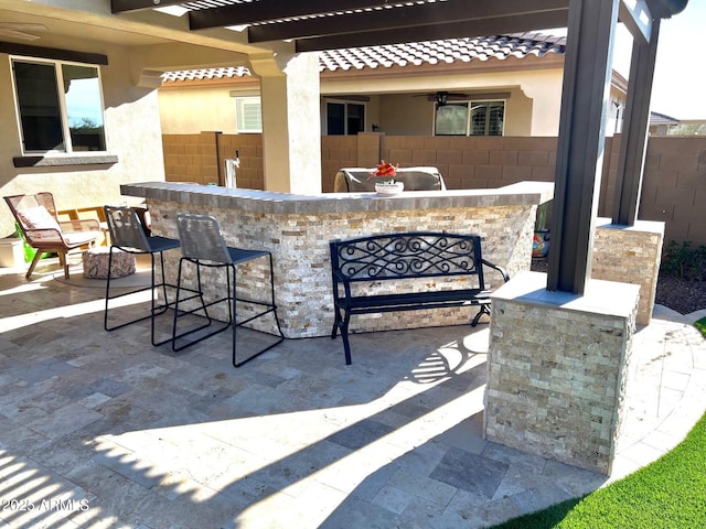 view of patio with fence and outdoor dry bar