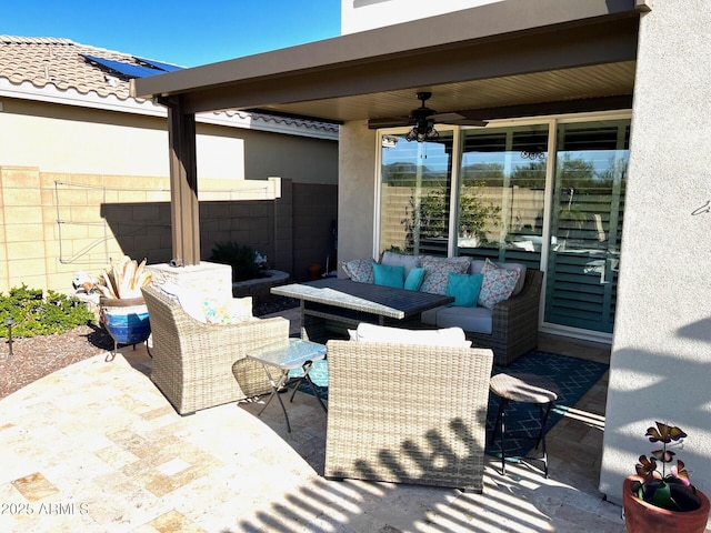 view of patio / terrace with a ceiling fan, fence, and an outdoor living space