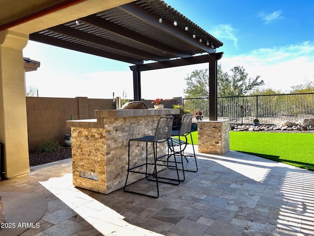 view of patio / terrace with exterior kitchen, a fenced backyard, outdoor wet bar, and a pergola