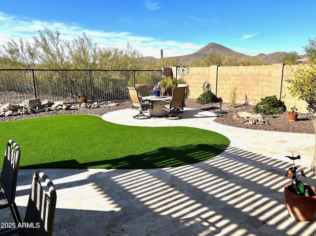 view of patio / terrace featuring a fenced backyard and a mountain view