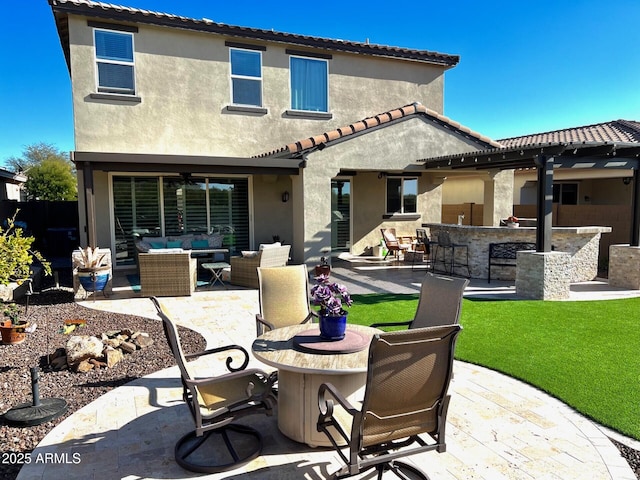 rear view of property featuring an outdoor hangout area, an outdoor bar, and a patio