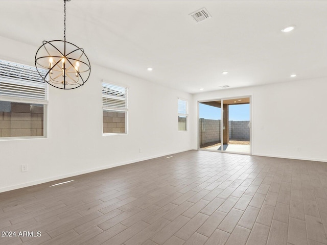 unfurnished room featuring hardwood / wood-style floors and a chandelier