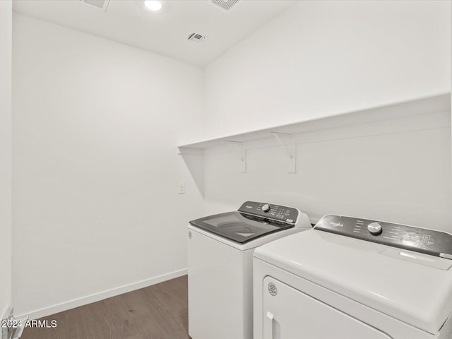 laundry area featuring washer and dryer and dark wood-type flooring