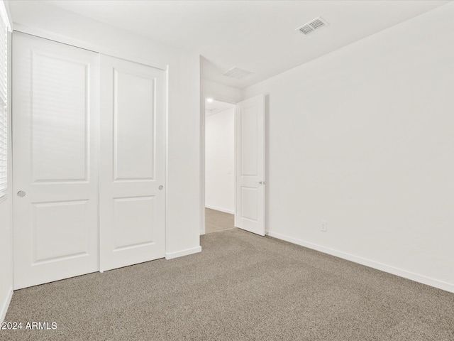 unfurnished bedroom featuring carpet and a closet