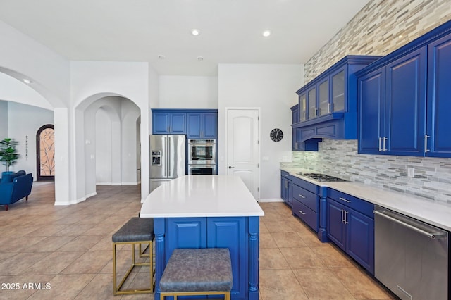 kitchen with blue cabinets, a center island, and appliances with stainless steel finishes