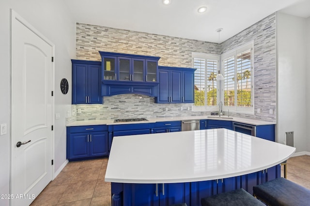 kitchen featuring blue cabinetry, a center island, and backsplash