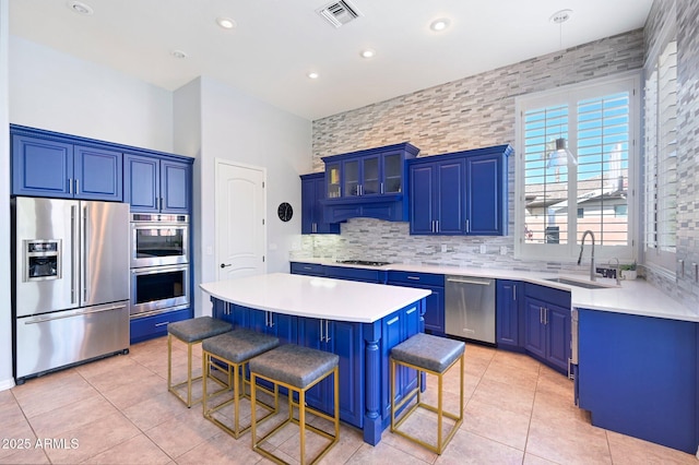 kitchen featuring sink, stainless steel appliances, a breakfast bar, and a kitchen island