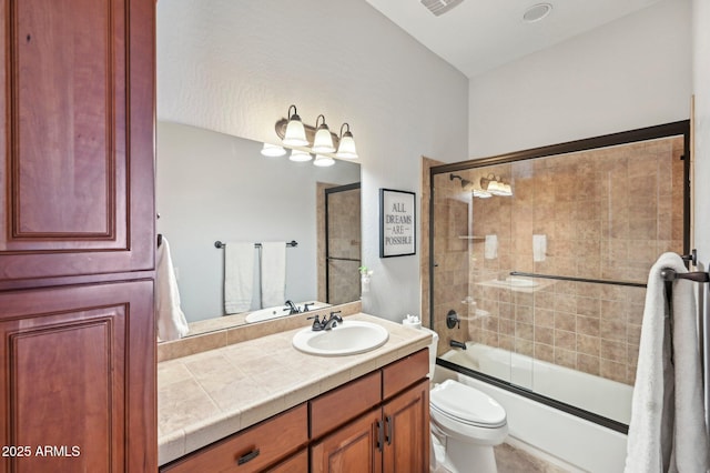 full bathroom featuring enclosed tub / shower combo, vanity, and toilet