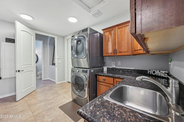 washroom featuring stacked washer and dryer, sink, and light tile patterned floors