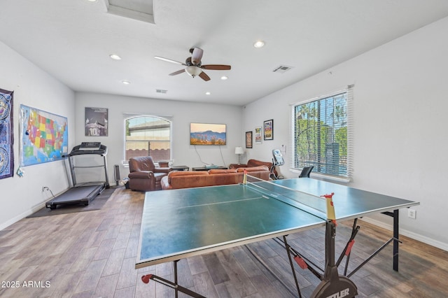 rec room featuring ceiling fan, wood-type flooring, and a healthy amount of sunlight