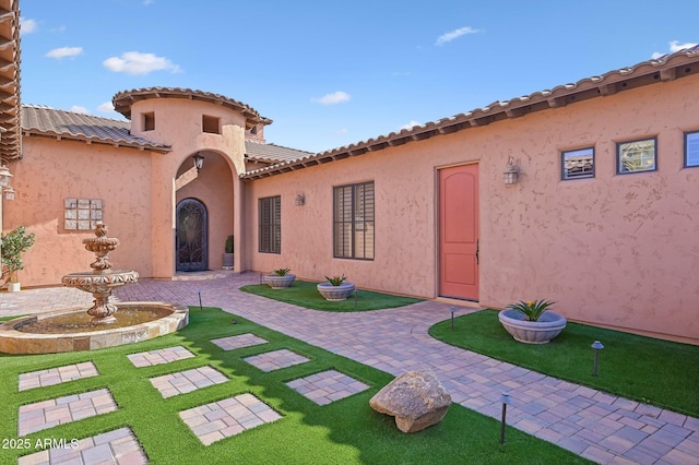 view of exterior entry with a patio