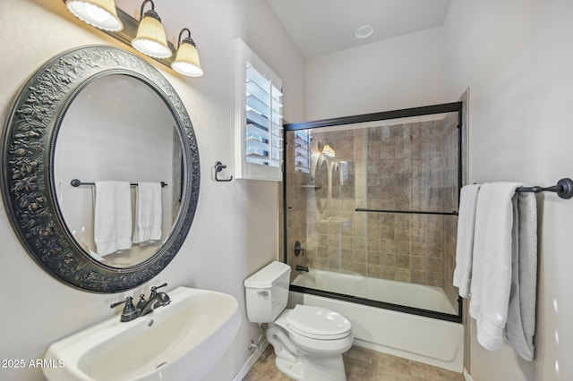 full bathroom with combined bath / shower with glass door, sink, and toilet