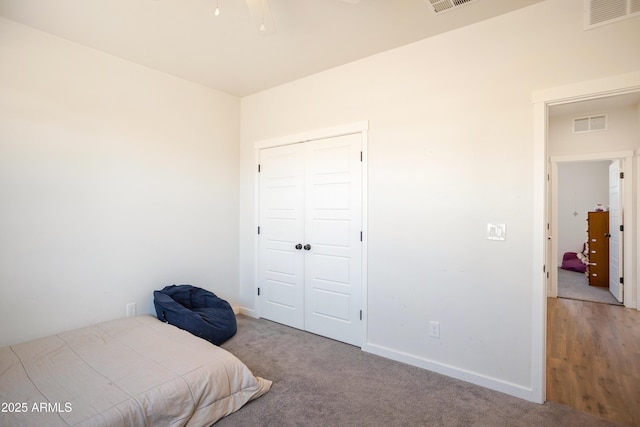 bedroom featuring carpet flooring, a closet, visible vents, and baseboards