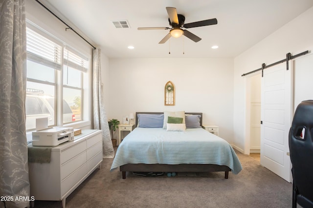 bedroom with a barn door, visible vents, carpet floors, and recessed lighting