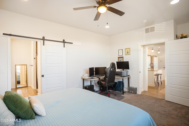 carpeted bedroom featuring recessed lighting, a ceiling fan, visible vents, and a barn door