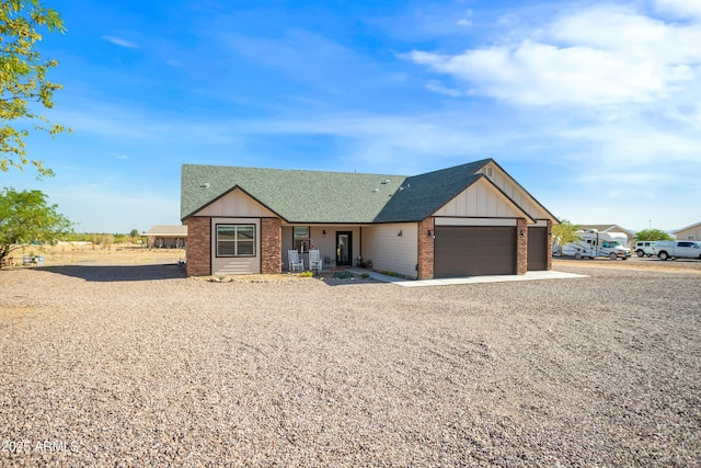 ranch-style house featuring brick siding, board and batten siding, a shingled roof, and an attached garage