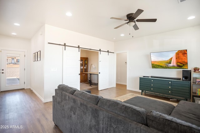 living room with recessed lighting, a barn door, a ceiling fan, baseboards, and wood finished floors