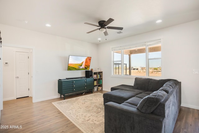 living room featuring ceiling fan, visible vents, baseboards, recessed lighting, and wood finished floors