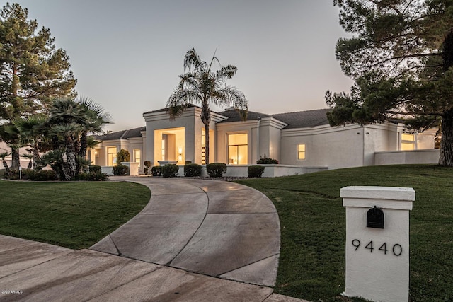 view of front of home with a yard and stucco siding