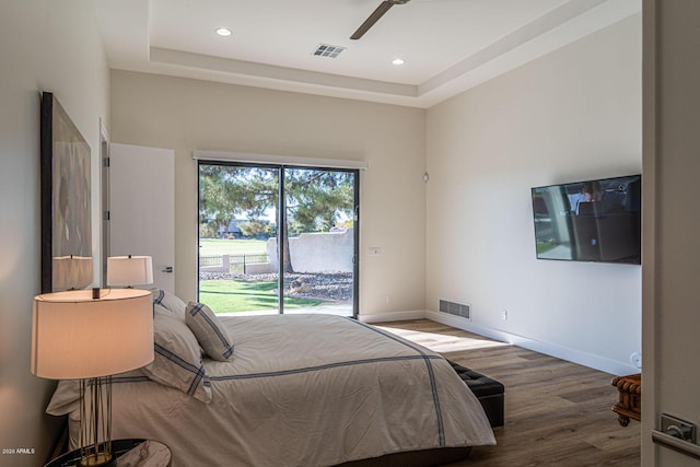 bedroom featuring baseboards, access to outside, visible vents, and wood finished floors