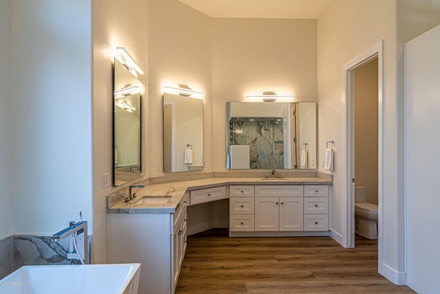 bathroom featuring toilet, a marble finish shower, a sink, and wood finished floors