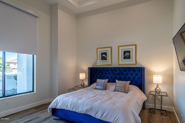 bedroom with wood finished floors, visible vents, and baseboards