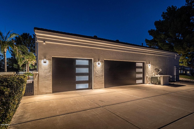 garage at night featuring fence