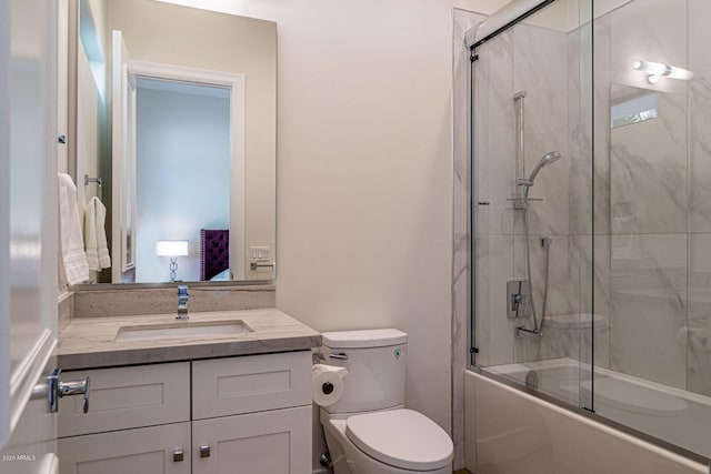 bathroom with toilet, shower / bath combination with glass door, and vanity