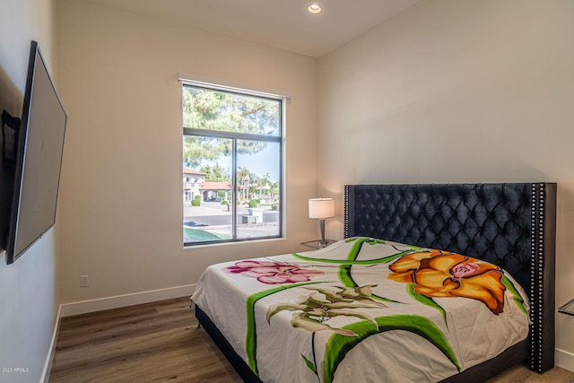 bedroom featuring baseboards, wood finished floors, and recessed lighting