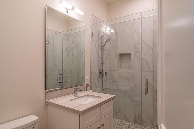 bathroom featuring toilet, vanity, and a marble finish shower