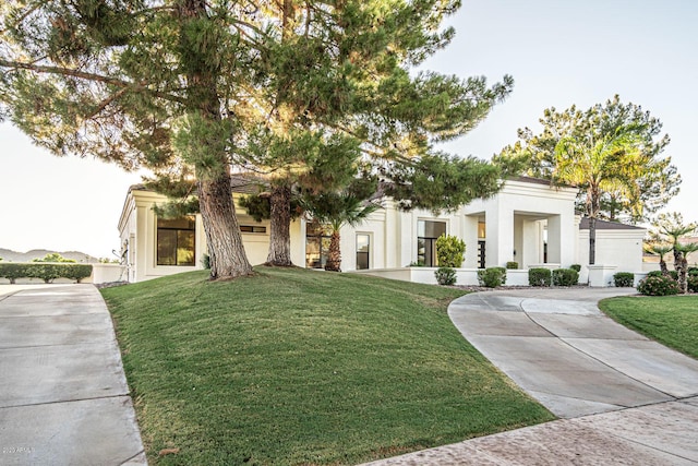 view of front of house with stucco siding and a front yard