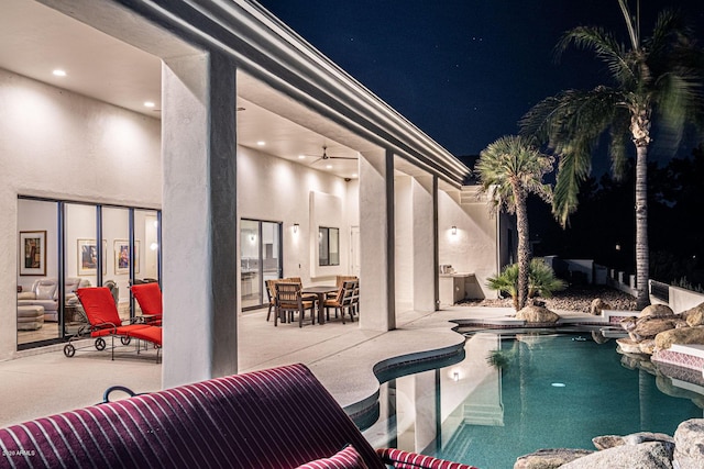 pool at twilight with a patio area and an outdoor pool