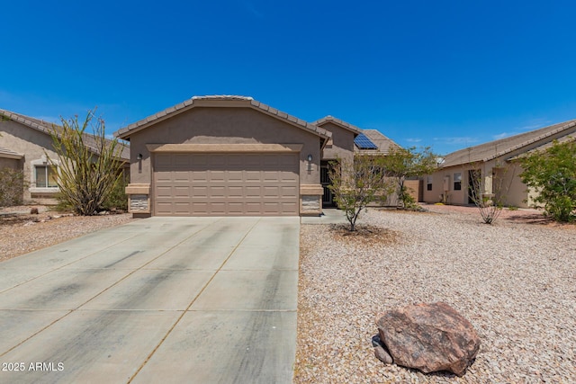 ranch-style house with a tiled roof, driveway, solar panels, a garage, and stucco siding