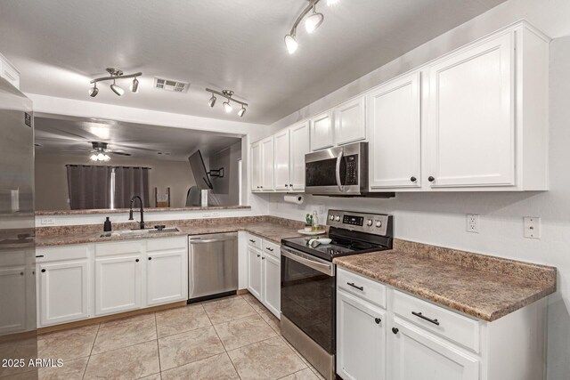 kitchen with a ceiling fan, visible vents, appliances with stainless steel finishes, a sink, and white cabinetry