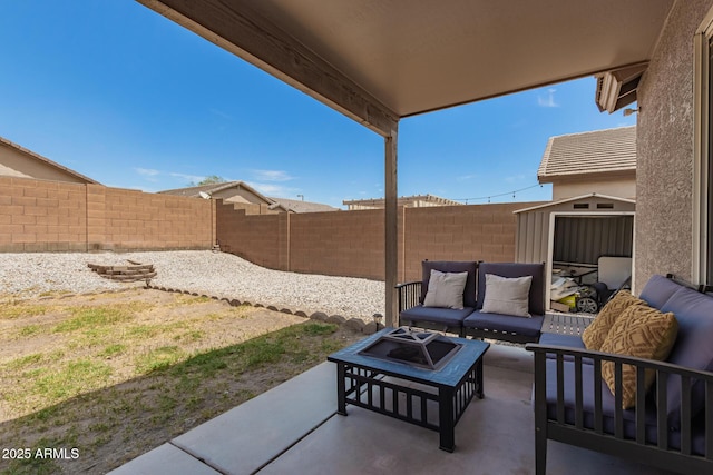 view of patio / terrace featuring a fenced backyard, a storage unit, and an outdoor living space with a fire pit