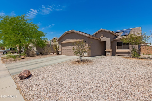 ranch-style home featuring stucco siding, roof mounted solar panels, an attached garage, driveway, and a tile roof