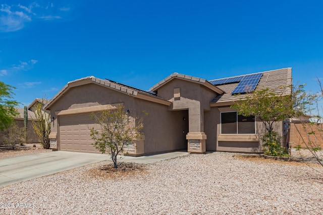 single story home with a tiled roof, driveway, a garage, roof mounted solar panels, and stucco siding