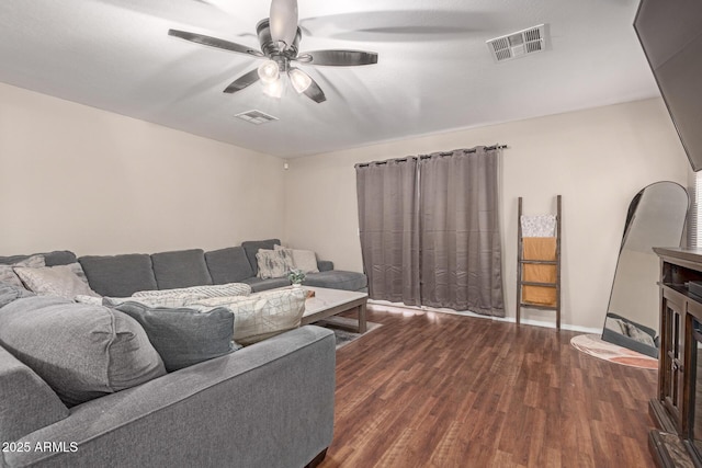 living area featuring a ceiling fan, baseboards, visible vents, and wood finished floors