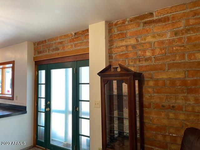 doorway featuring brick wall