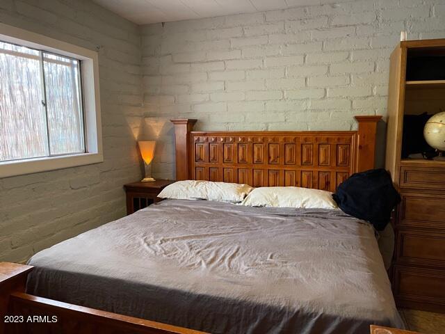 bedroom featuring brick wall