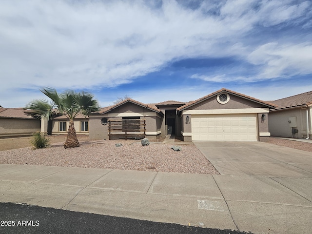 ranch-style home with concrete driveway, a tiled roof, an attached garage, and stucco siding