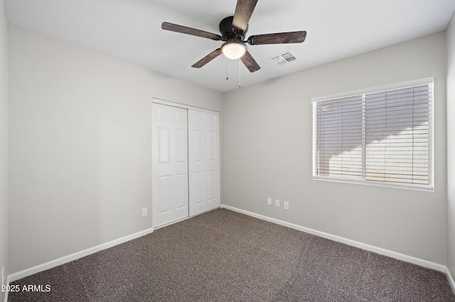 unfurnished bedroom with visible vents, baseboards, ceiling fan, carpet, and a closet