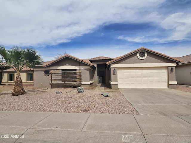 single story home featuring a garage, driveway, a tiled roof, and stucco siding