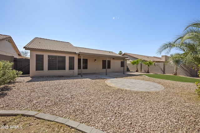 back of house with a patio, a fenced backyard, a tiled roof, and stucco siding