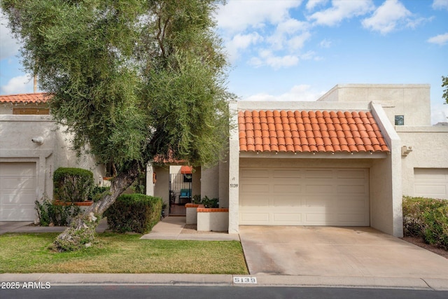 view of front facade featuring driveway, a tiled roof, and stucco siding