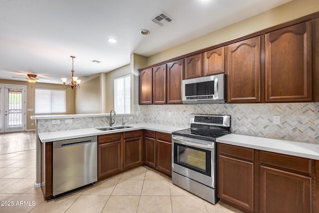 kitchen featuring visible vents, appliances with stainless steel finishes, light tile patterned flooring, a sink, and a peninsula