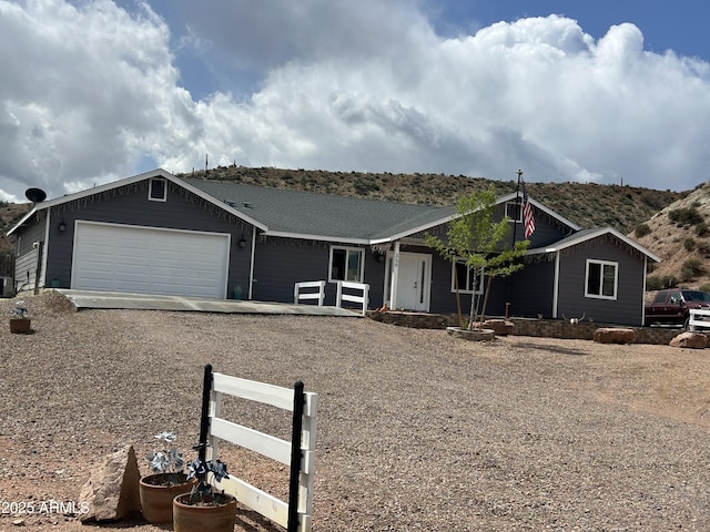ranch-style house featuring driveway, a garage, fence, and covered porch