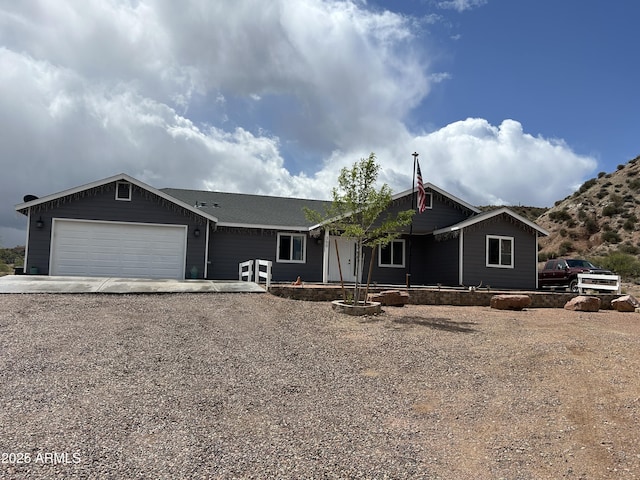 ranch-style house featuring an attached garage and gravel driveway
